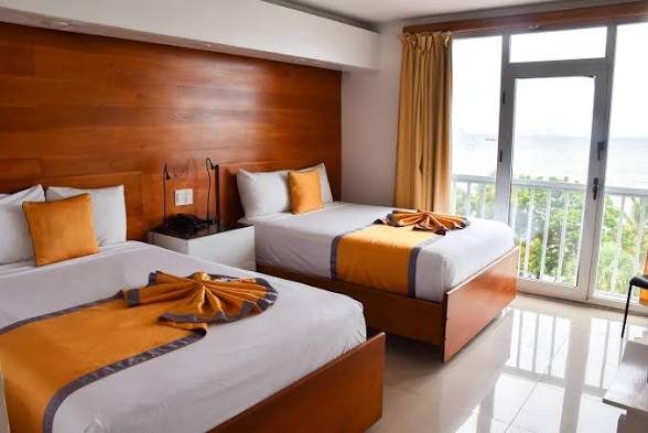 Habitación con dos camas, balcón y vista al mar
