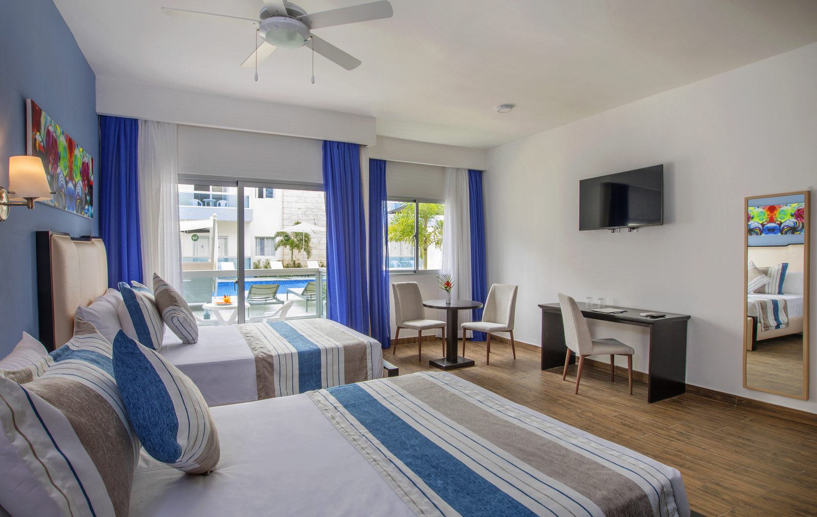 Habitación con dos camas y balcón sobre la piscina